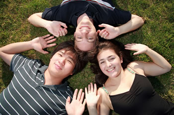 stock photo of a group of teens laying in the grass